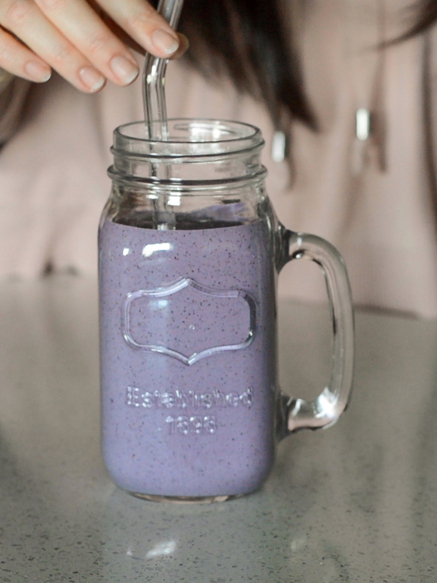 Protein fruit smoothie in mason cup with glass straw