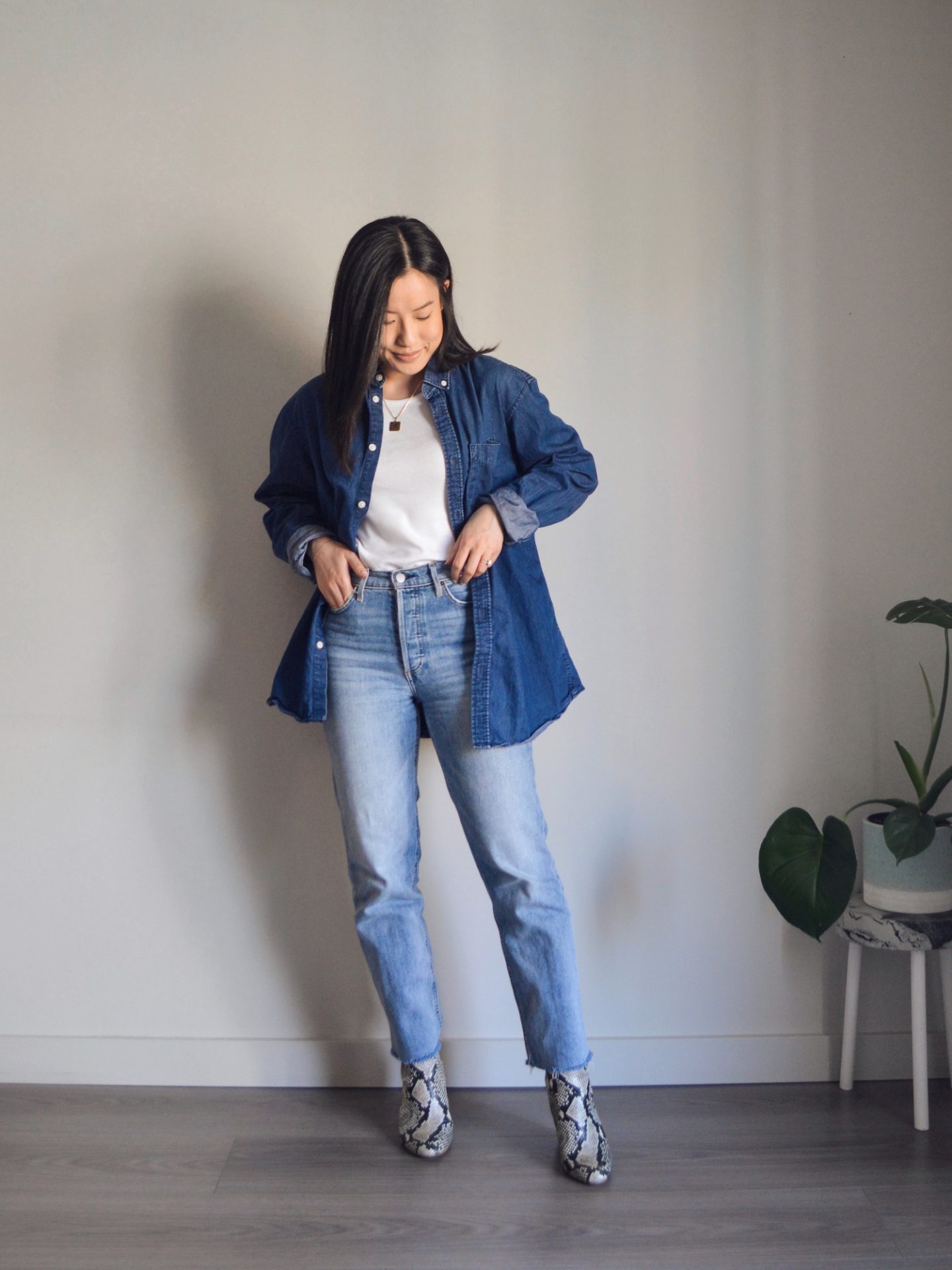 Outfit details: oversized denim shirt, white tank top, blue straight leg jeans, faux snake skin ankle boots