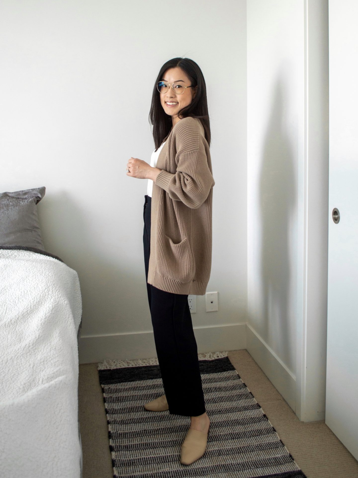 Her Simple Sole - outfit details: cozy oversized cardigan, white henley top, black trousers, nude coloured mules