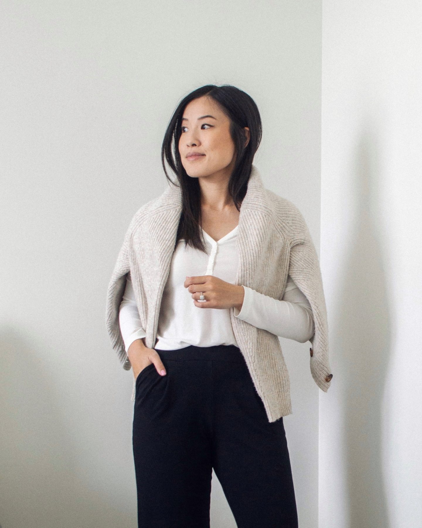 Outfit details - knit cardigan over shoulders, white henley top, black wide leg pants, cozy outfit, work from home outfit