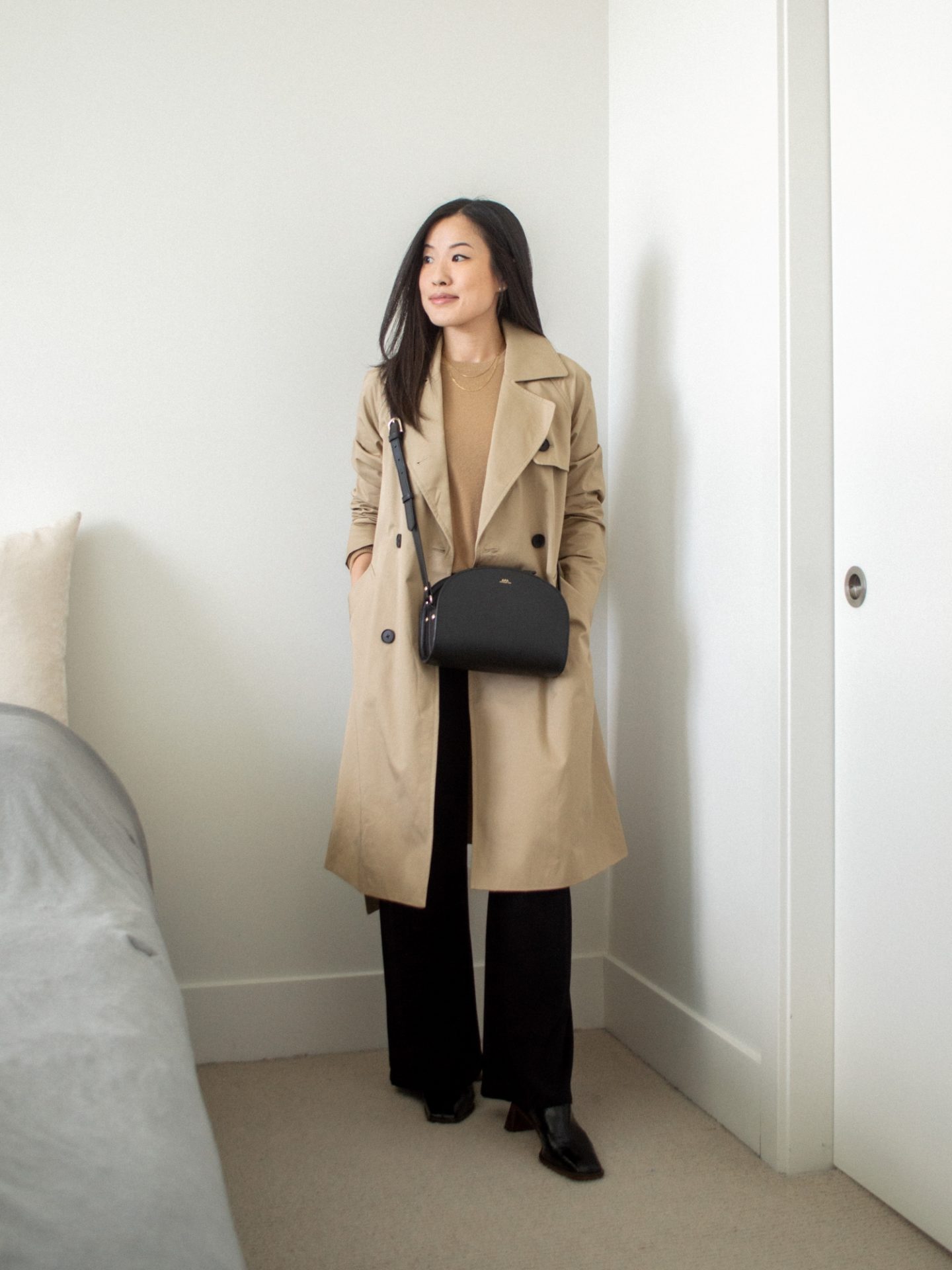 Outfit Details: camel trench coat, camel cashmere crewneck sweater, black cross-body bag, wide leg pants, heeled mules