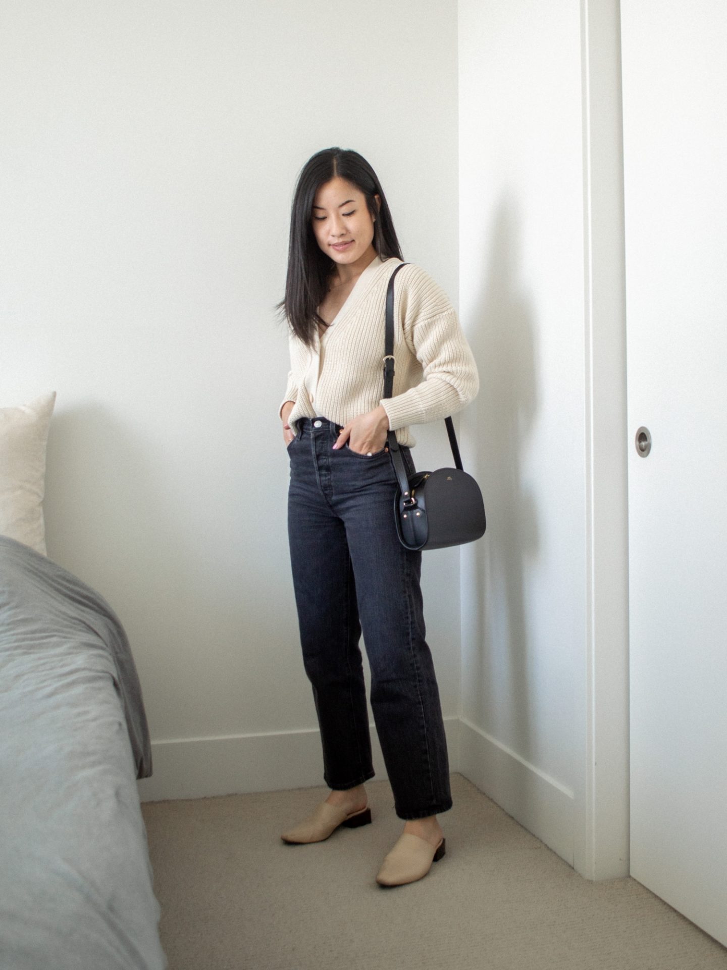 Her Simple Sole outfit details: oversized cardigan with straight leg jeans, neutral coloured mules and a half moon bag