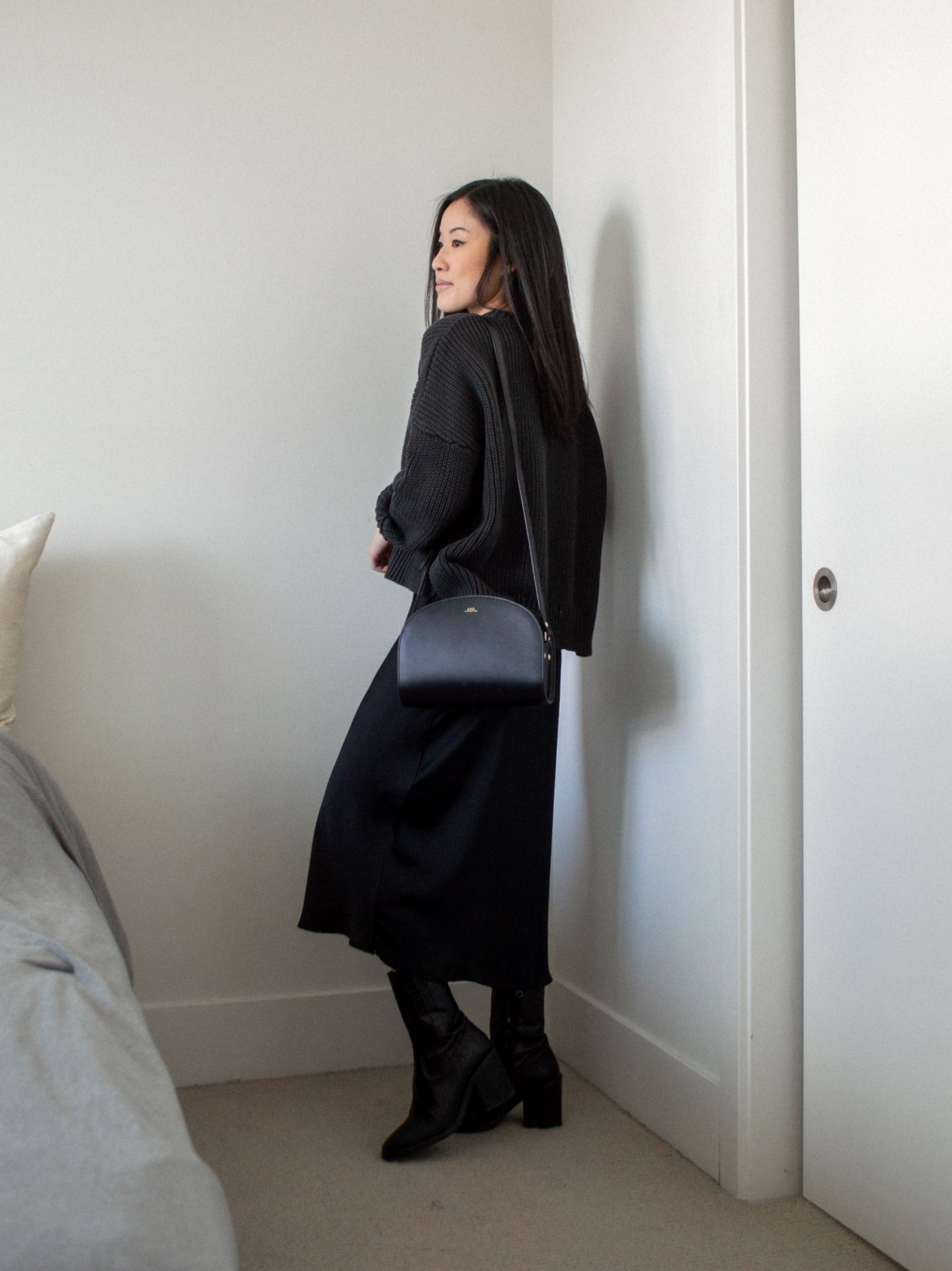 Outfit details - cropped black knitted sweater, black slip dress, mid-calf black boots, half moon bag