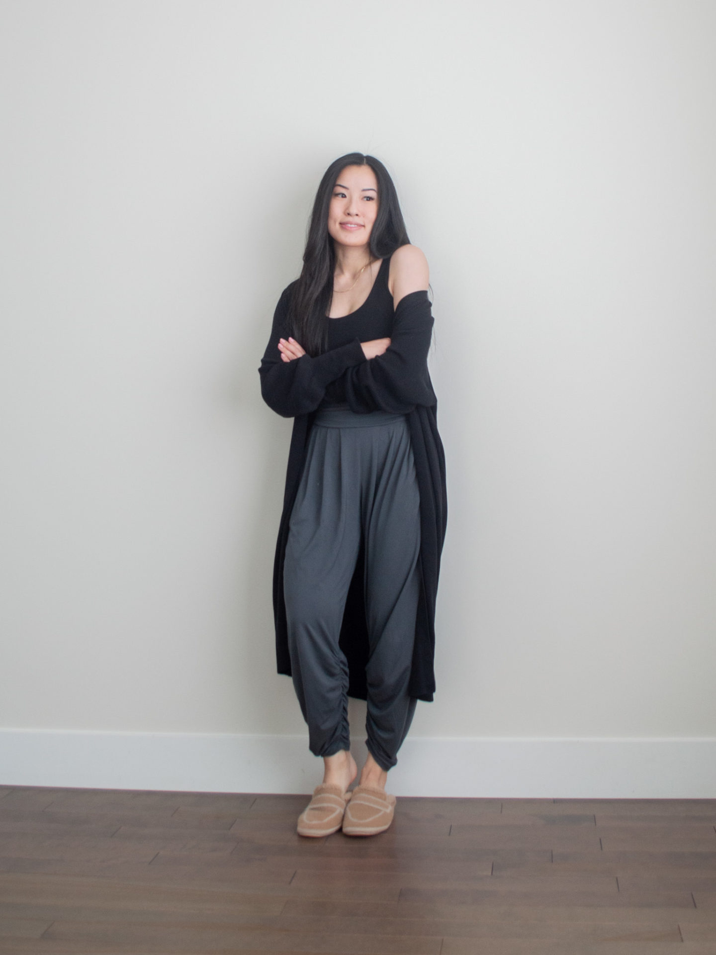 Her Simple Sole outfit photo wearing a cozy long black duster cardigan, black cropped tank top, comfortable pants with calf ruching, and fluffy slippers, work from home casual outfit, casual loungewear outfit ideas