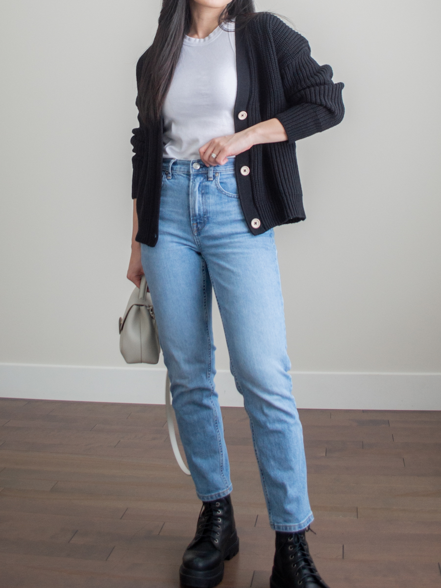 Her Simple Sole outfit photo featuring a black cotton cardigan, a white cotton high neck tank top, blue straight leg jeans, black chunky combat boots, and an off-white crossbody bag