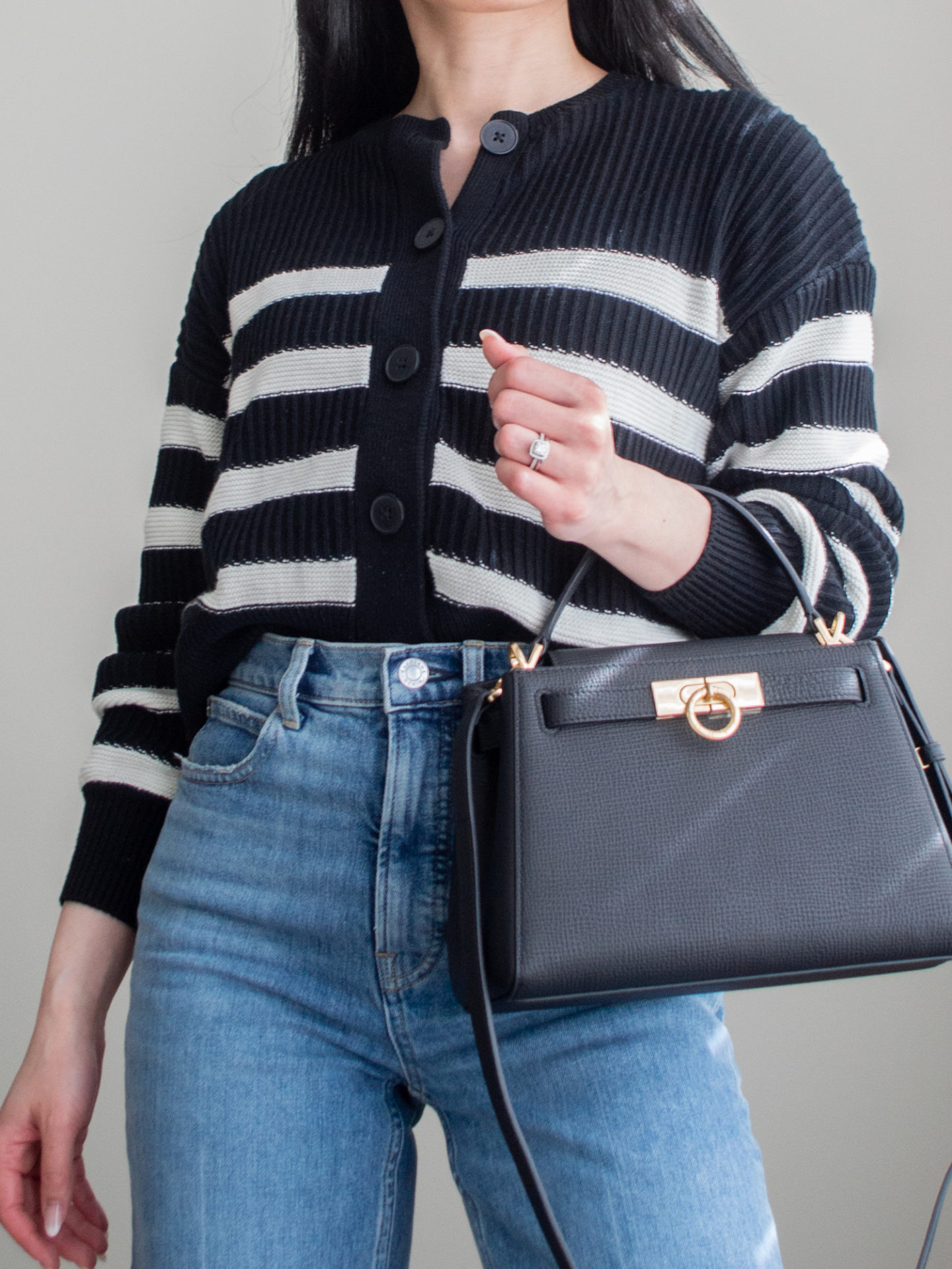 Smart casual outfit idea: black and white stripe cardigan, blue straight leg jeans, square crossbody bag