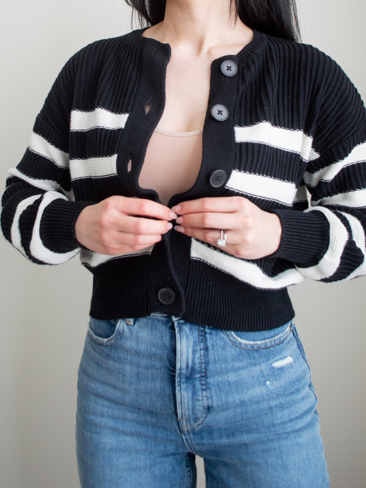 Close up shot of outfit: black and white stripe cardigan, Numi The Crop Undershirt, blue straight leg jeans