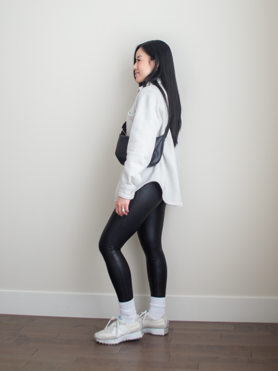 Athletisure outfit featuring a white shirt jack, basic white t-shirt, black leggings, new balance 327 sneakers. slouchy crossbody bag | casual spring outfit