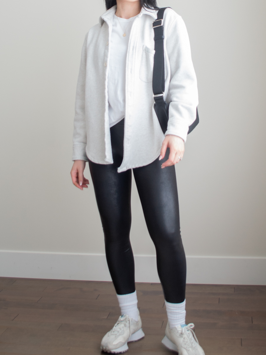 Athletisure outfit featuring a white shirt jack, basic white t-shirt, black leggings, new balance 327 sneakers. slouchy crossbody bag | casual spring outfit