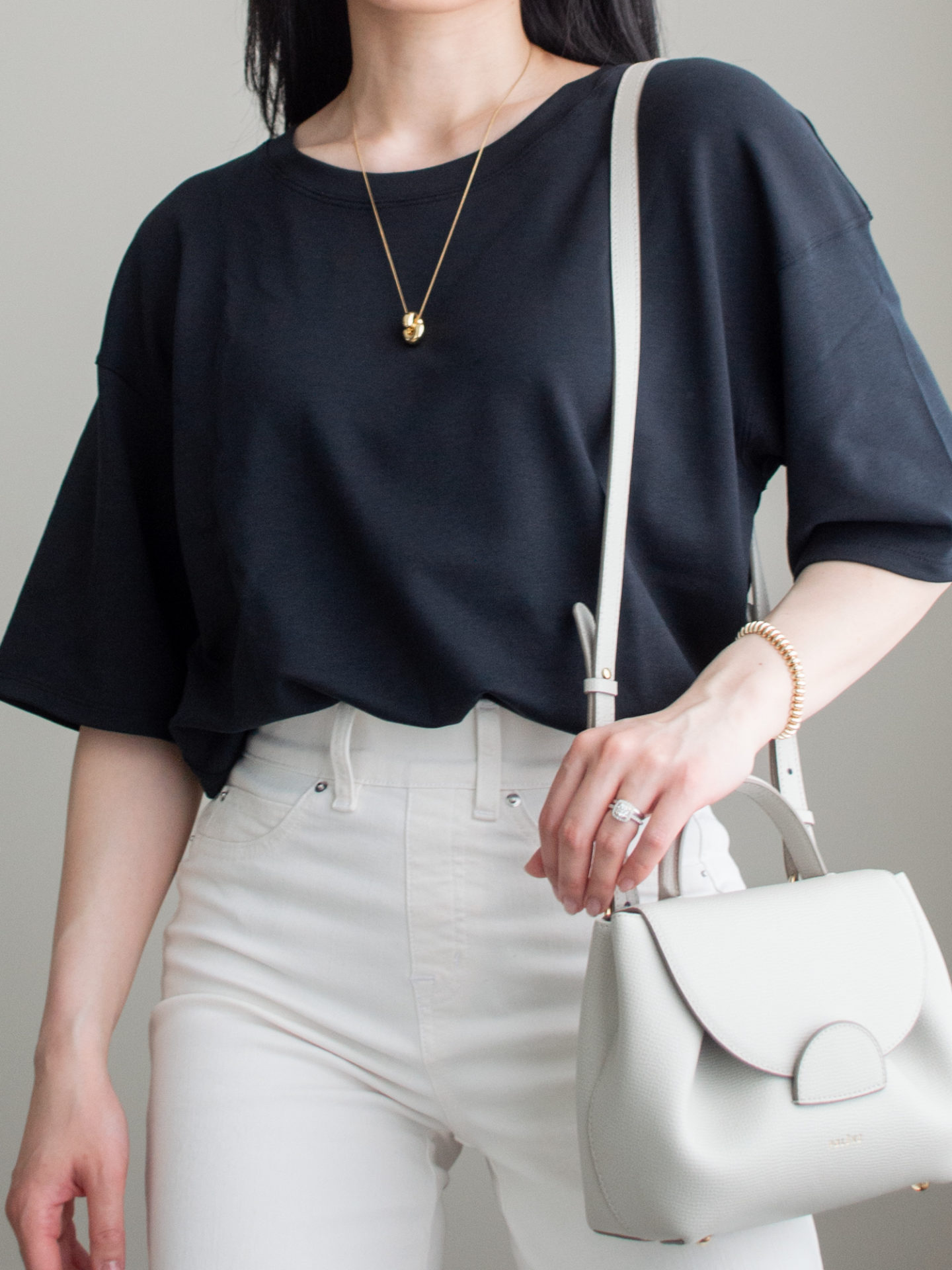 Close-up detailed outfit shot of Sharon of Her Simple Sole wearing minimal, comfortable, and functional items from her intentional wardrobe | minimalist outfit ideas | black and white monochrome outfit | cream wide leg jeans outfit | smart casual outfit