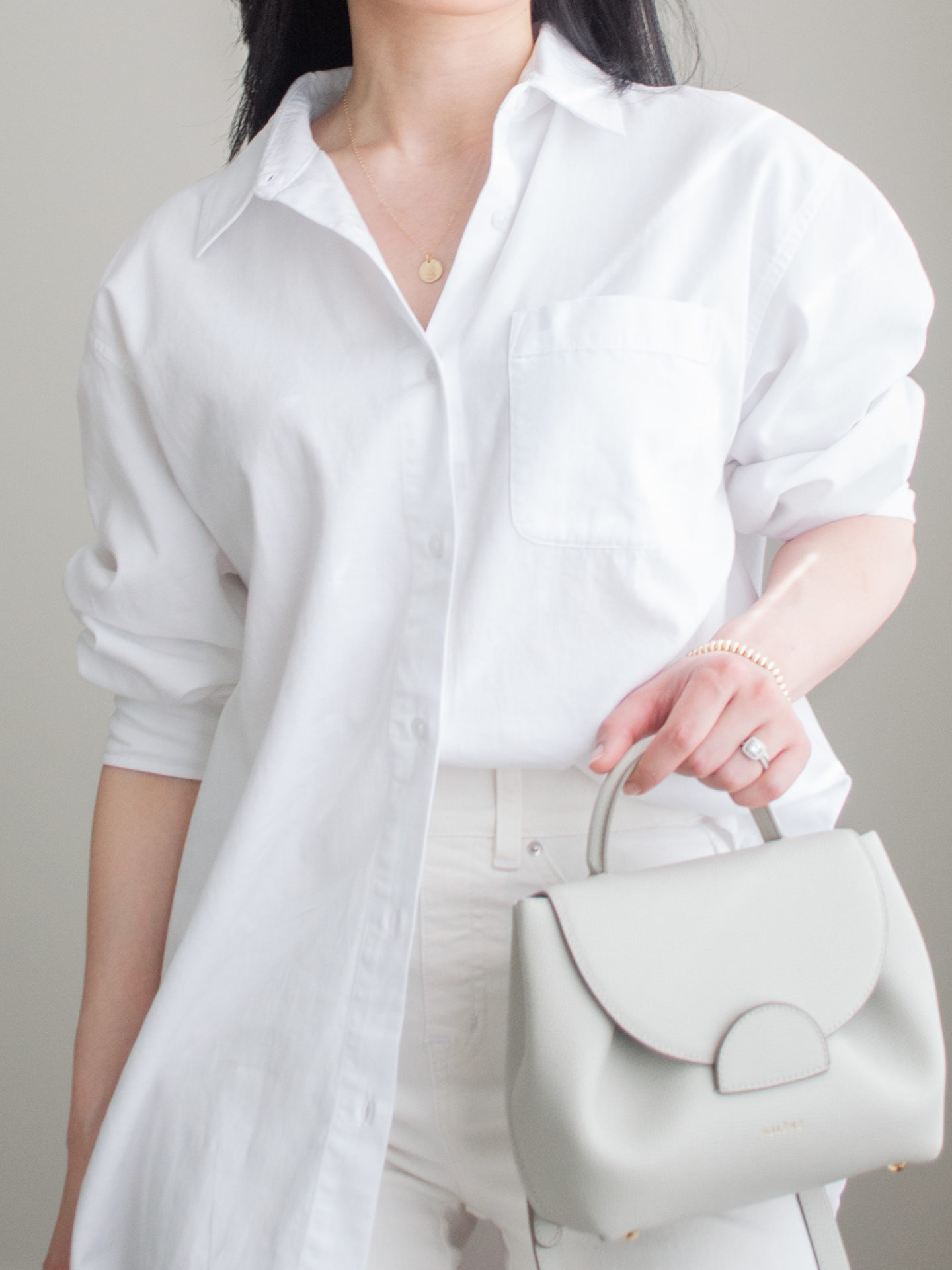 Close-up detailed outfit shot of Sharon of Her Simple Sole wearing minimal, comfortable, and functional items from her intentional wardrobe | minimalist outfit ideas | white monochrome outfit | cream wide leg jeans outfit | smart casual outfit | white oversized button up shirt outfit