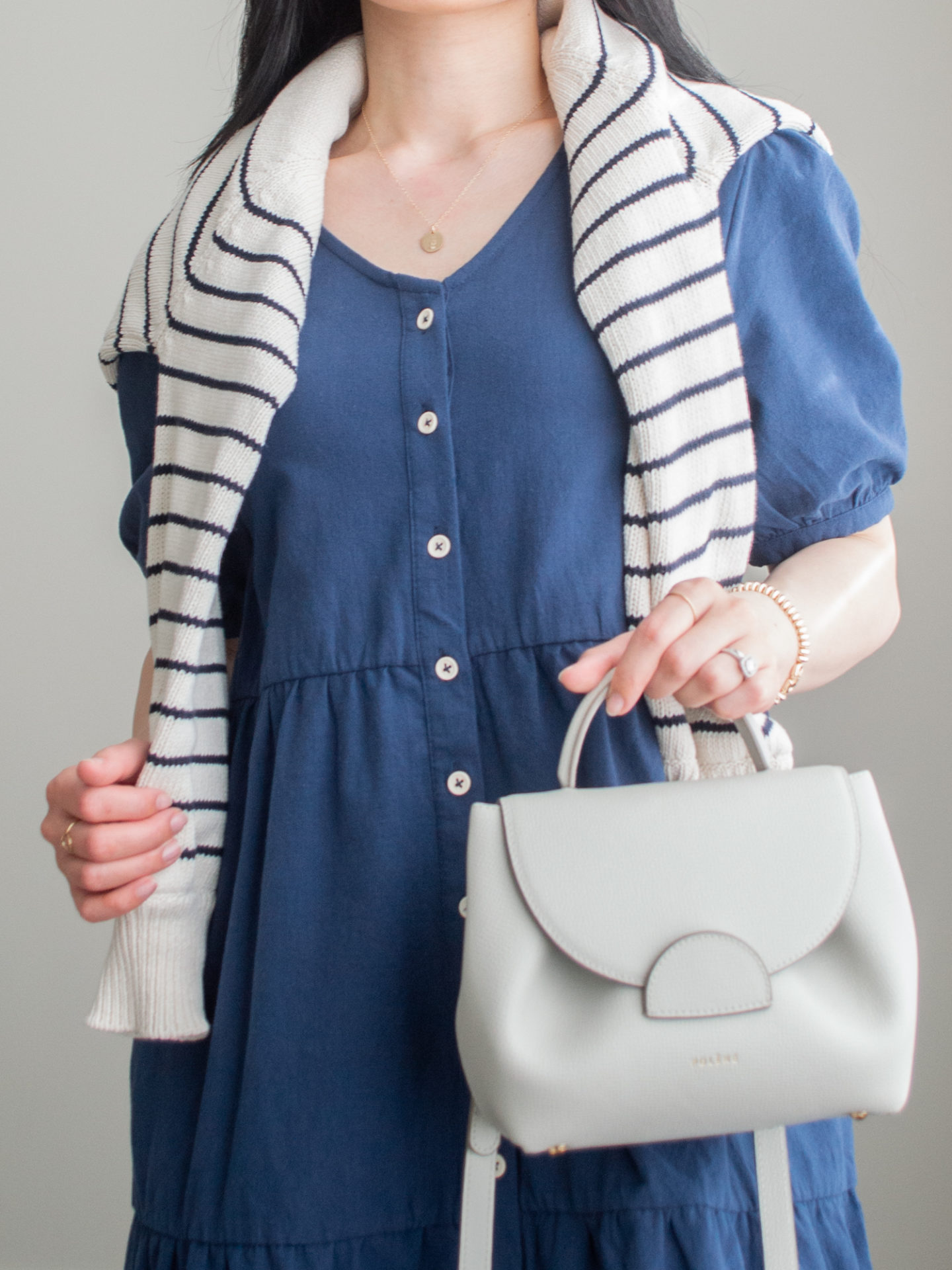 Close-up detailed outfit shot of Sharon of Her Simple Sole wearing minimal, comfortable, and functional items from her intentional wardrobe | minimalist outfit ideas | blue tiered midi dress outfit | sweater over the shoulders outfit