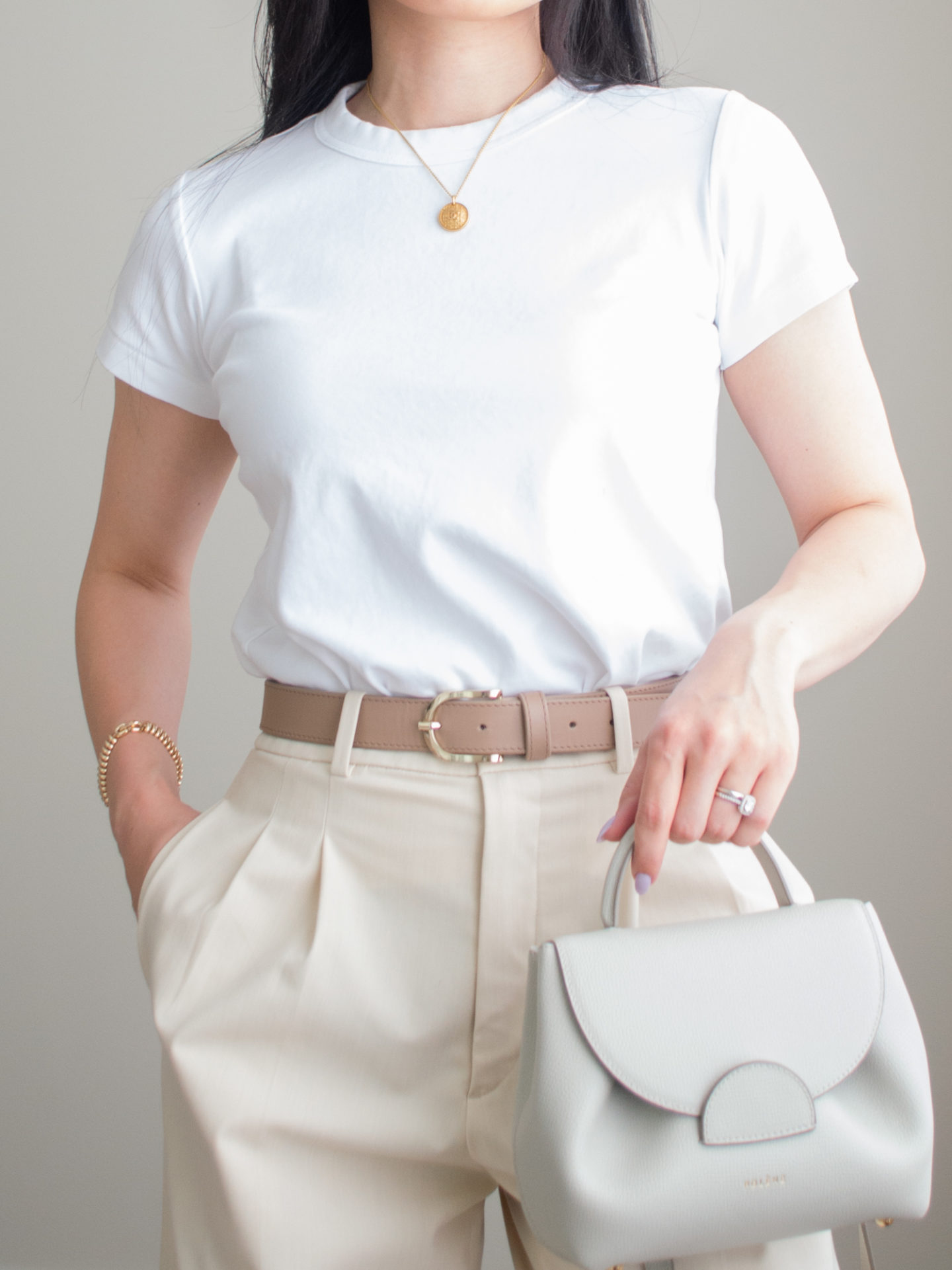 Close-up detailed outfit shot of Sharon of Her Simple Sole wearing a basic white t-shirt and cream wide leg pants with a neutral belt and Polene bag | minimalist outfit ideas | smart casual outfit