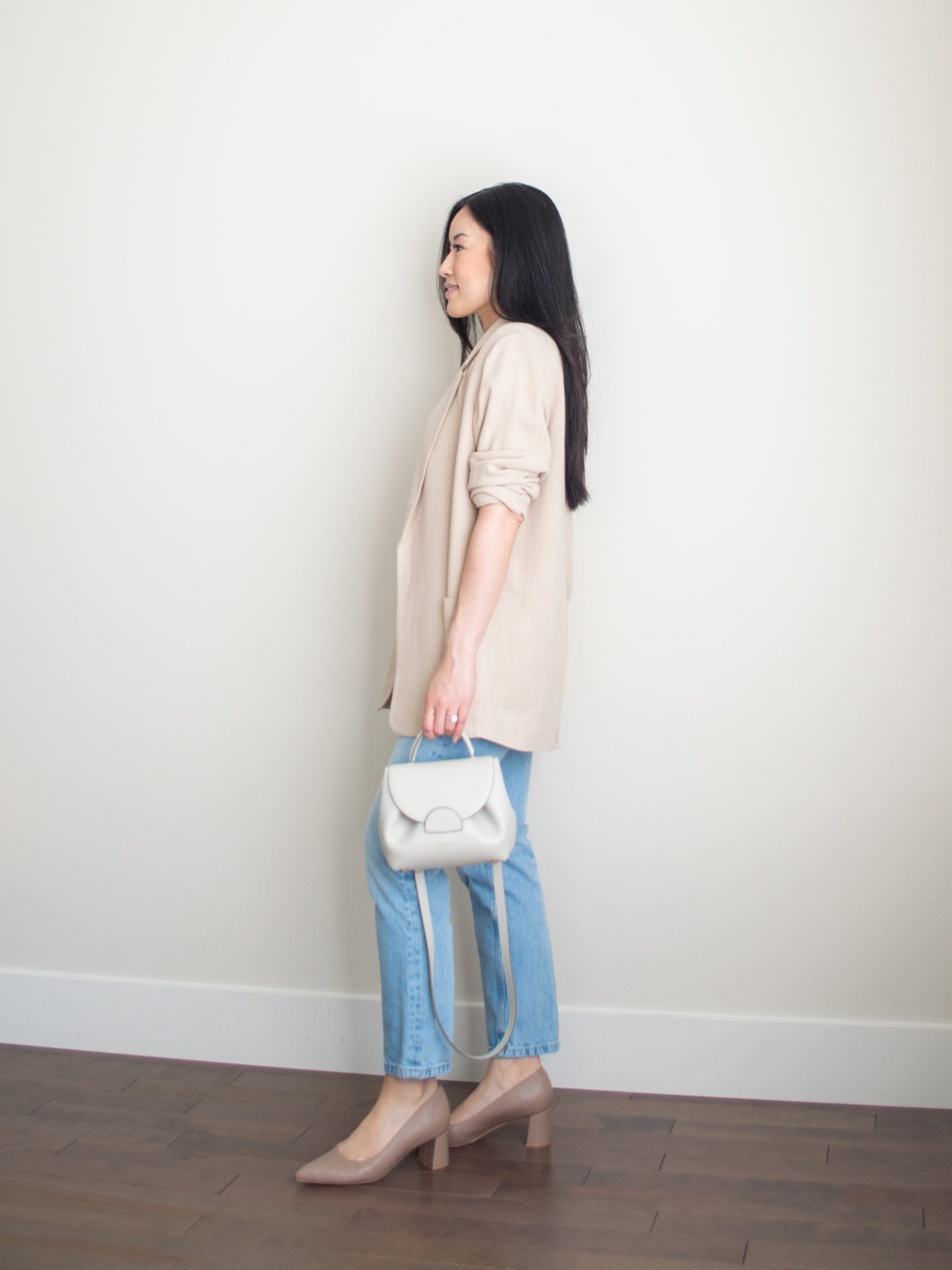 Sharon of Her Simple Sole is wearing a white basic t-shirt, blue straight leg jeans, a flowy linen blend blazer, and block heels from Ally Shoes, while holding an off-white crossbody bag | minimalist outfit ideas | smart casual outfit | comfortable pumps