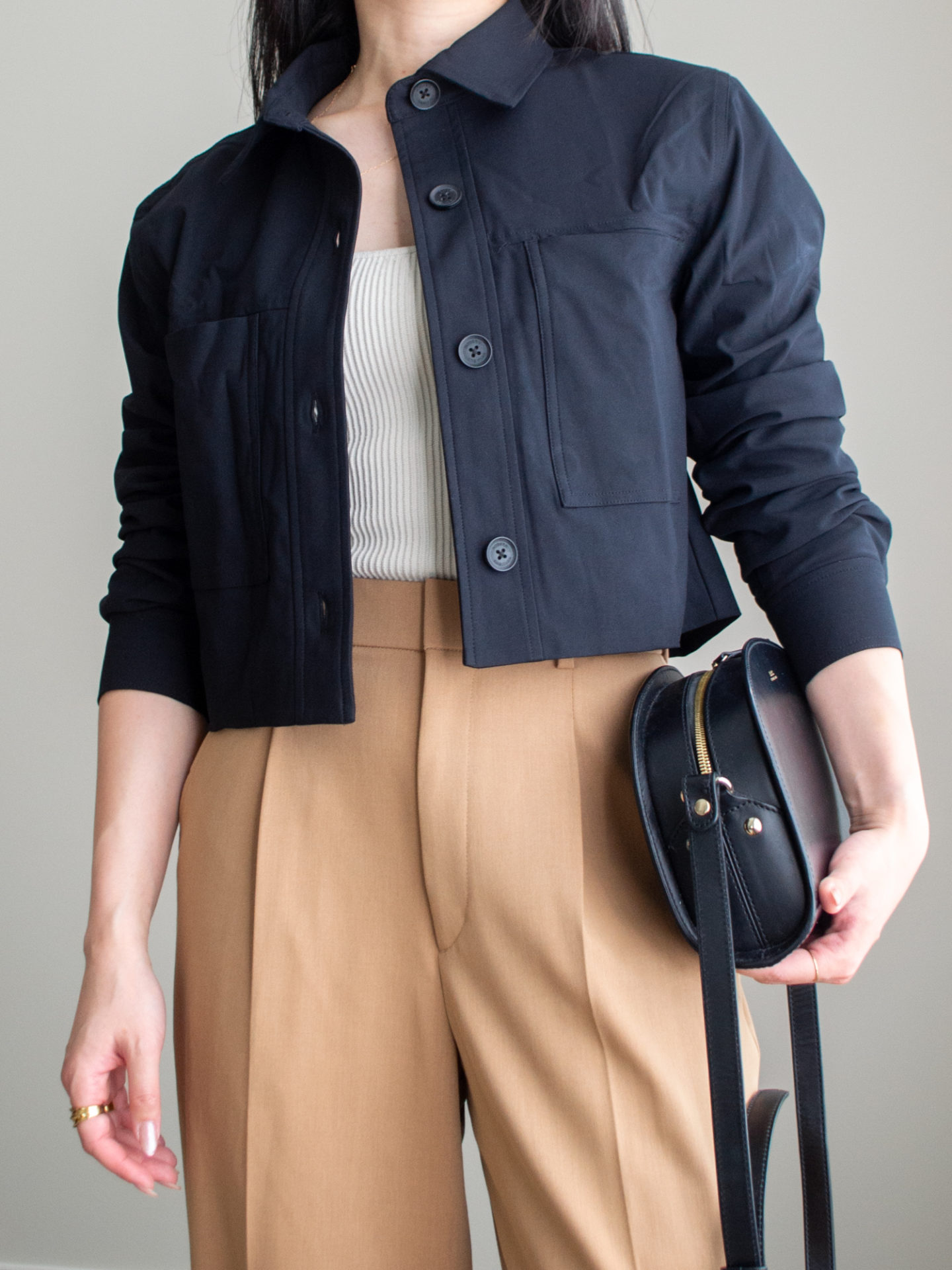 Close-up detailed outfit shot of Sharon of Her Simple Sole wearing a square neck tank top, a cropped jacket, and brown wide leg pants, while wearing a half moon black crossbody bag | minimalist outfit ideas | smart casual outfit