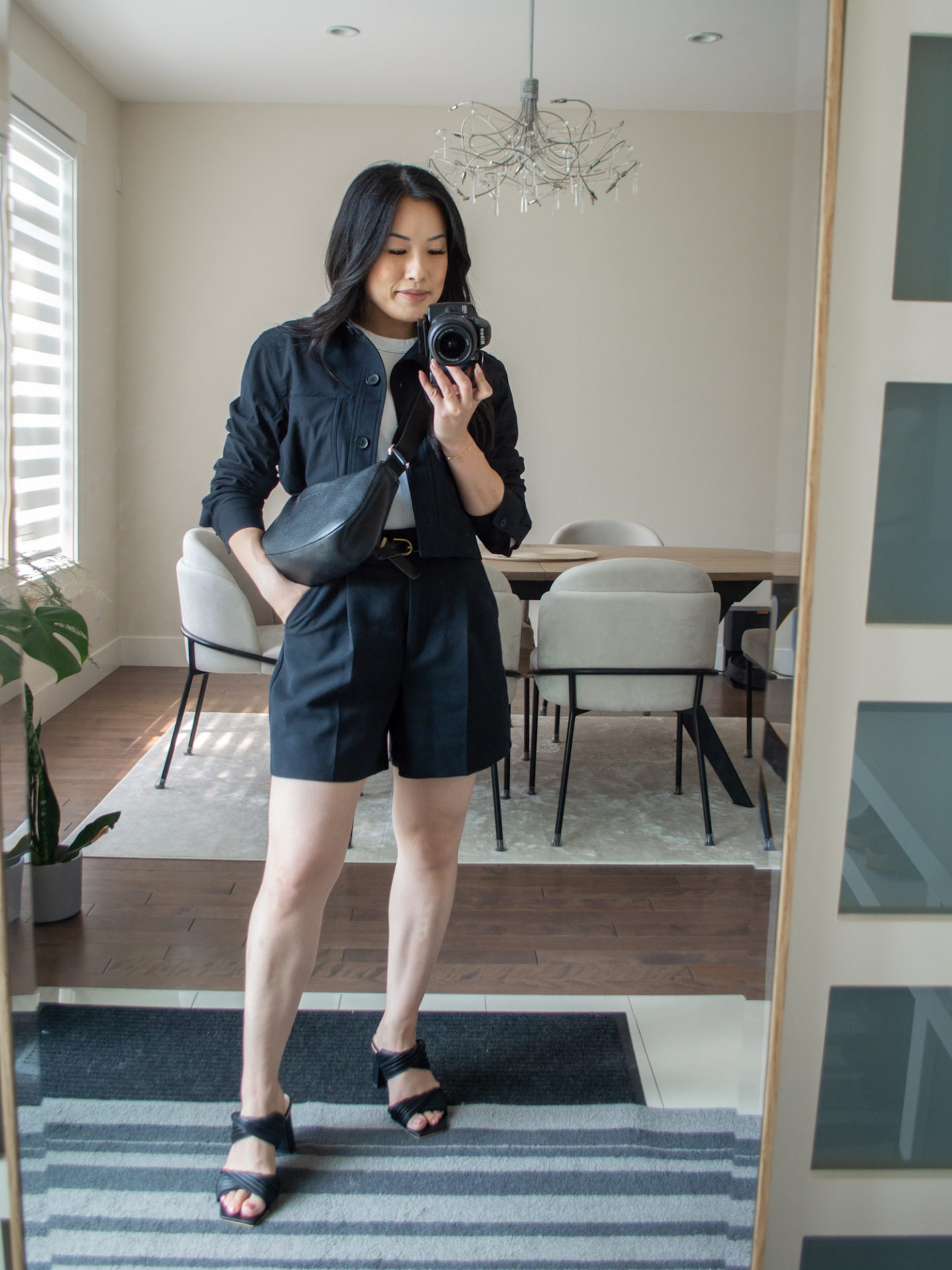 Sharon of Her Simple Sole is showcasing an outfits using simple pieces that make deciding what to pack easy, featuring a white baby T-Shirt, a black cropped jacket, black tailored shorts, a black slouchy bag and black heeled sandals | minimalist outfits | simple outfit ideas