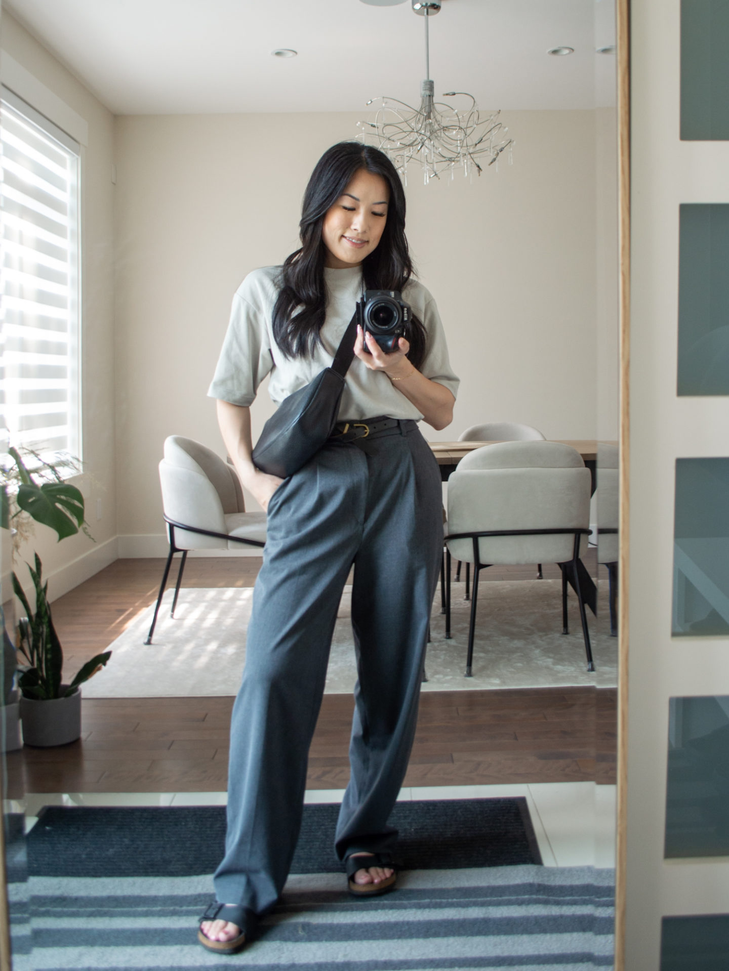 Sharon of Her Simple Sole is showcasing an outfits using simple pieces that make deciding what to pack easy, featuring a grey oversized T-Shirt, grey wide-leg pants, a black slouchy bag and buckle sandals | minimalist outfits | simple outfit ideas