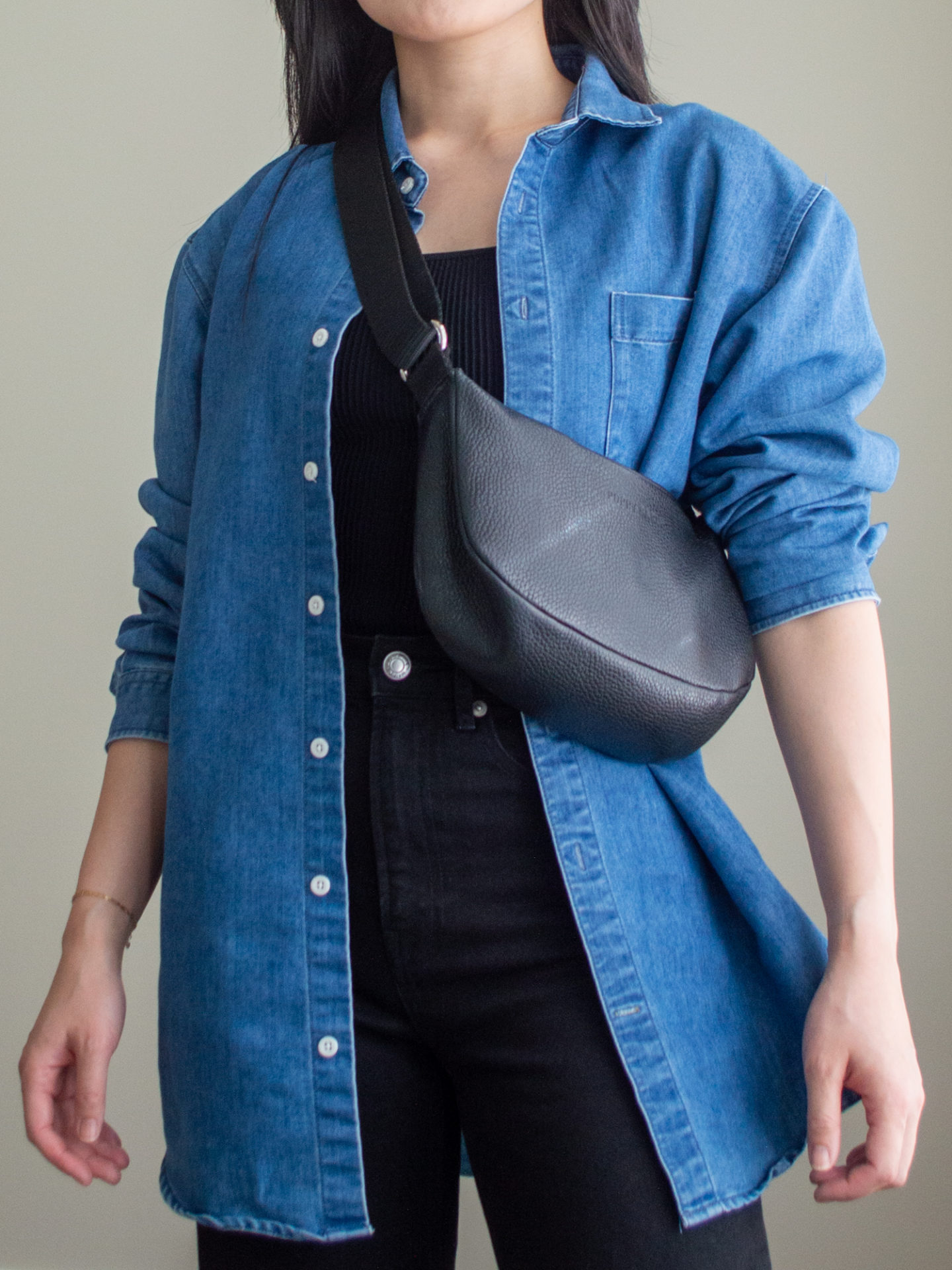 Close-up detailed outfit shot of Sharon of Her Simple Sole wearing a black square neck tank top, an oversized denim shirt, black straight leg jeans, a black slouchy bag | minimalist outfits | simple outfit ideas