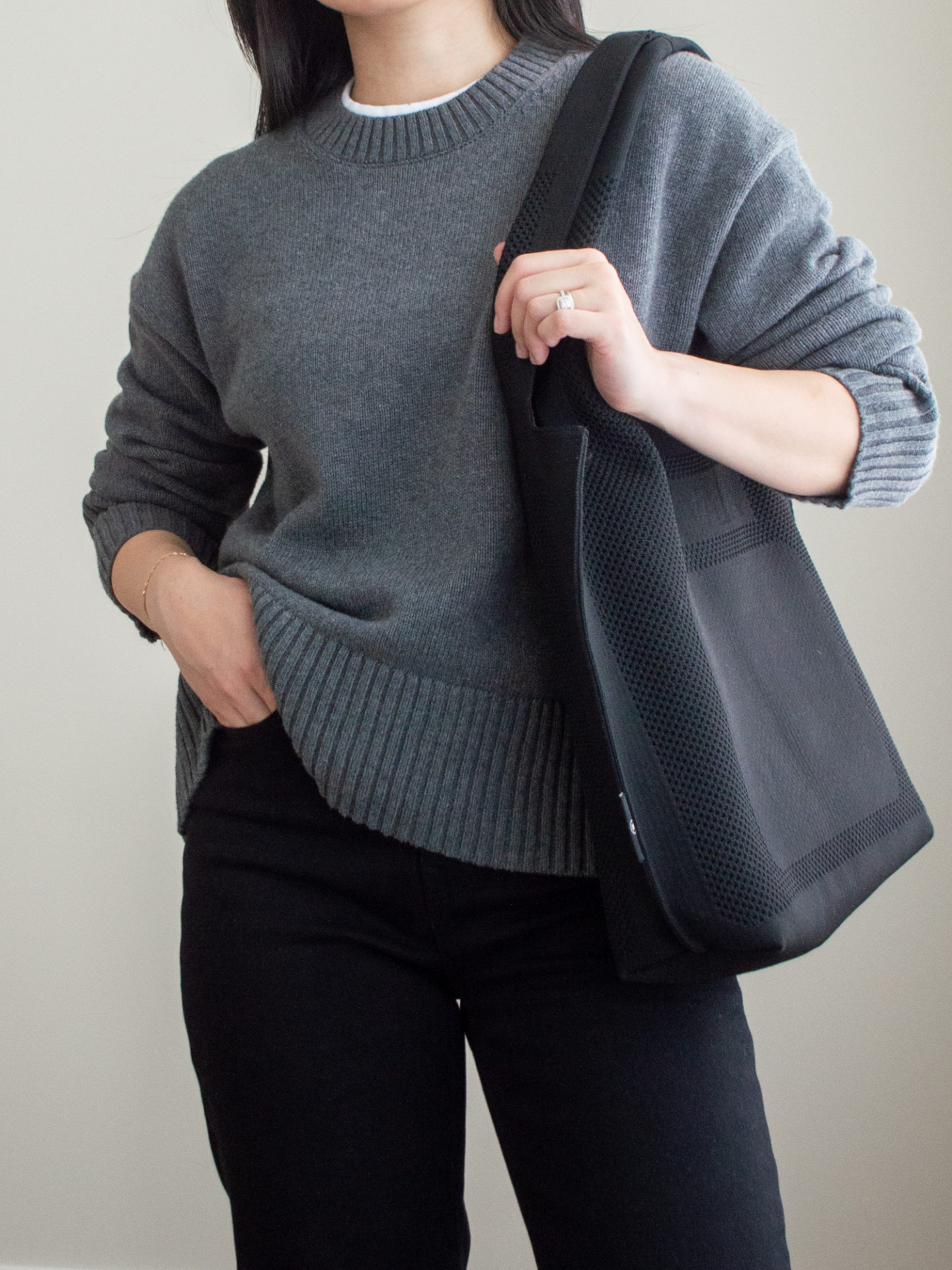 Close-up detailed outfit shot of Sharon of Her Simple Sole wearing a grey sweater, a white t-shirt inside, black straight leg jeans and a black tote bag | minimalist outfits | simple outfit ideas