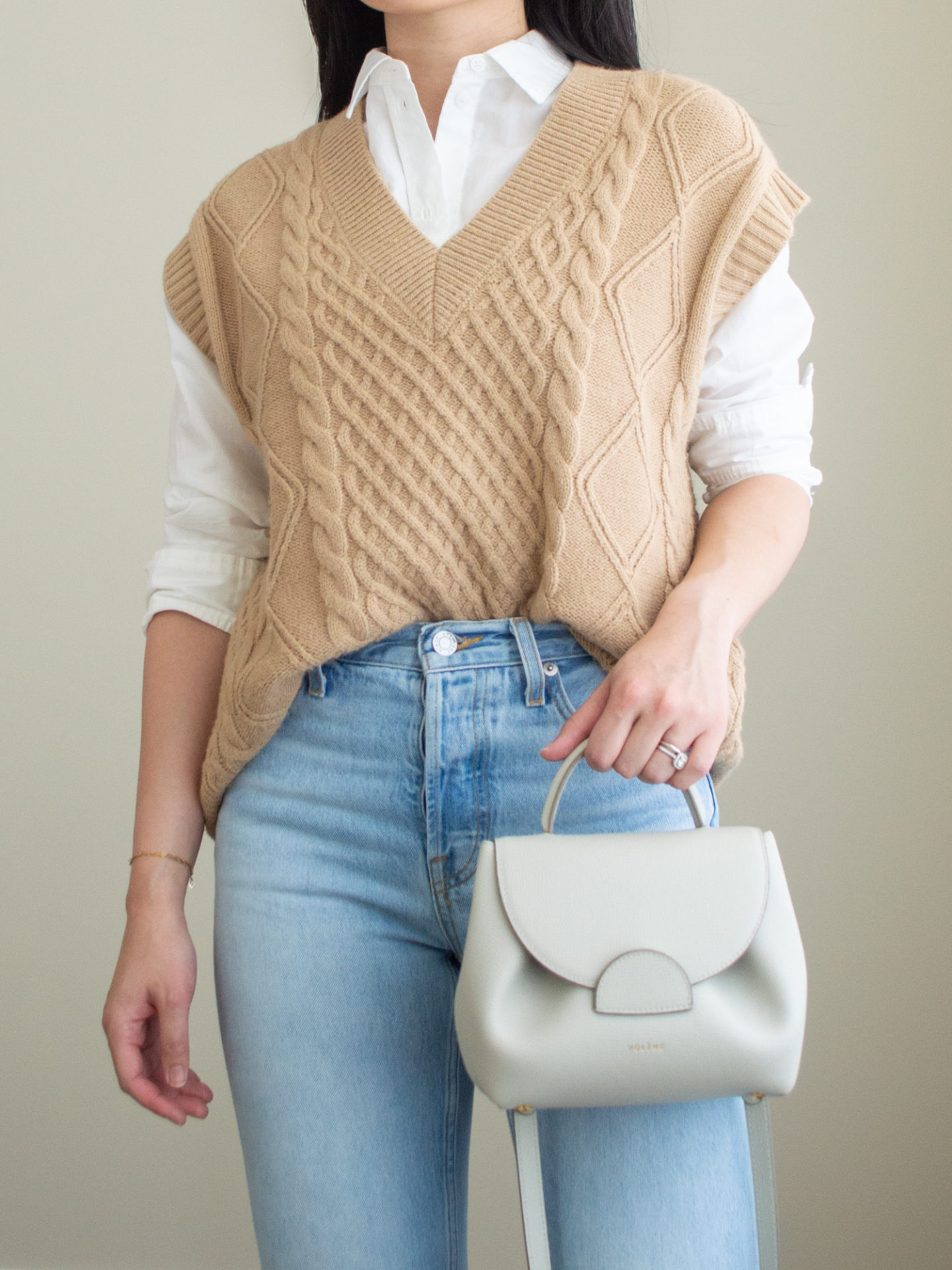 Close-up detailed outfit shot of Sharon of Her Simple Sole wearing a white button up shirt, a brown sweater vest, blue straight-leg jeans and an off-white crossbody bag | minimalist outfits | simple outfit ideas