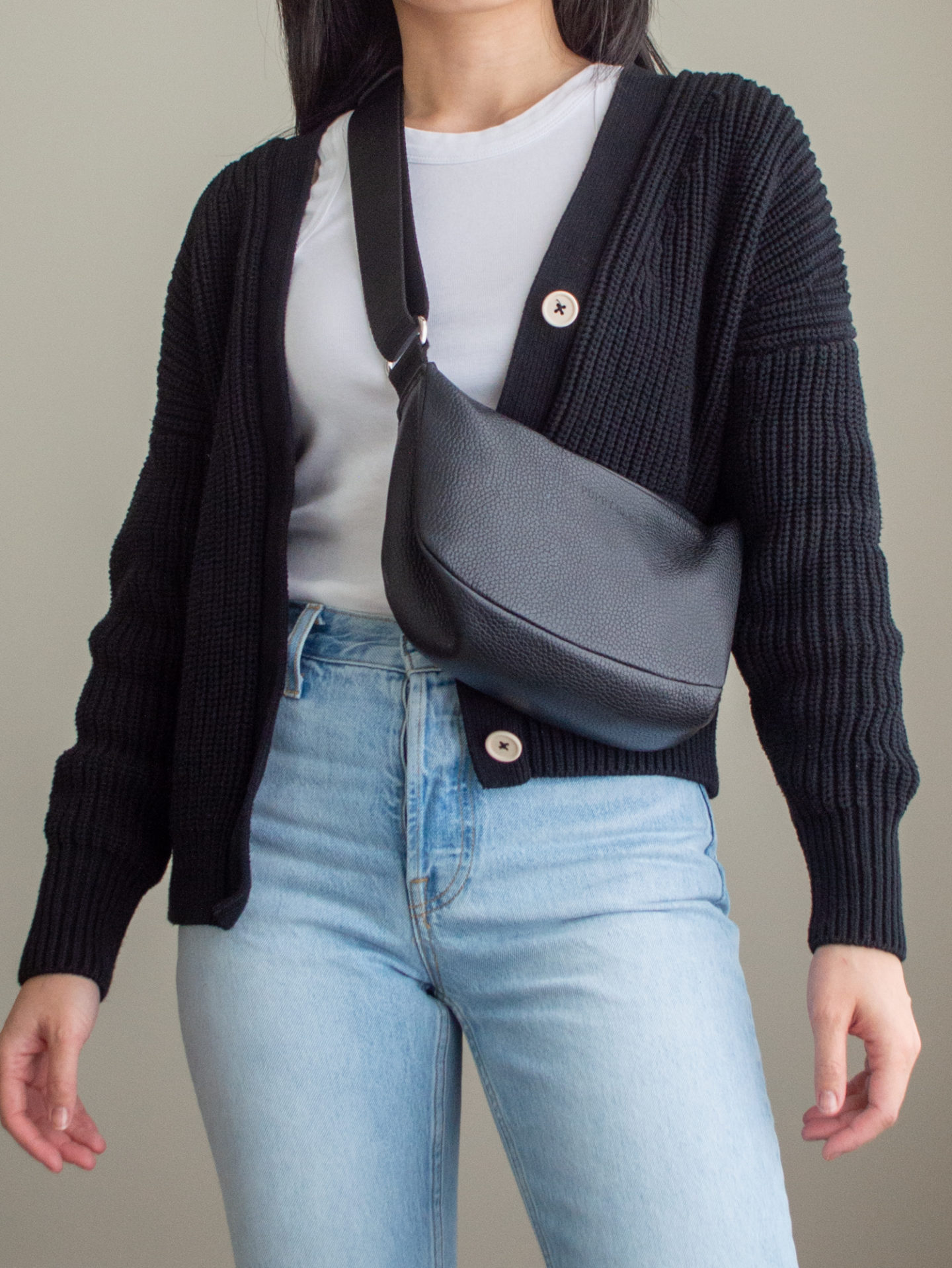 Close-up detailed outfit shot of Sharon of Her Simple Sole wearing a basic white tank top, a black cotton cardigan, a pair of blue straight-fit jeans, and a black slouchy bag | minimalist outfits | simple outfit ideas