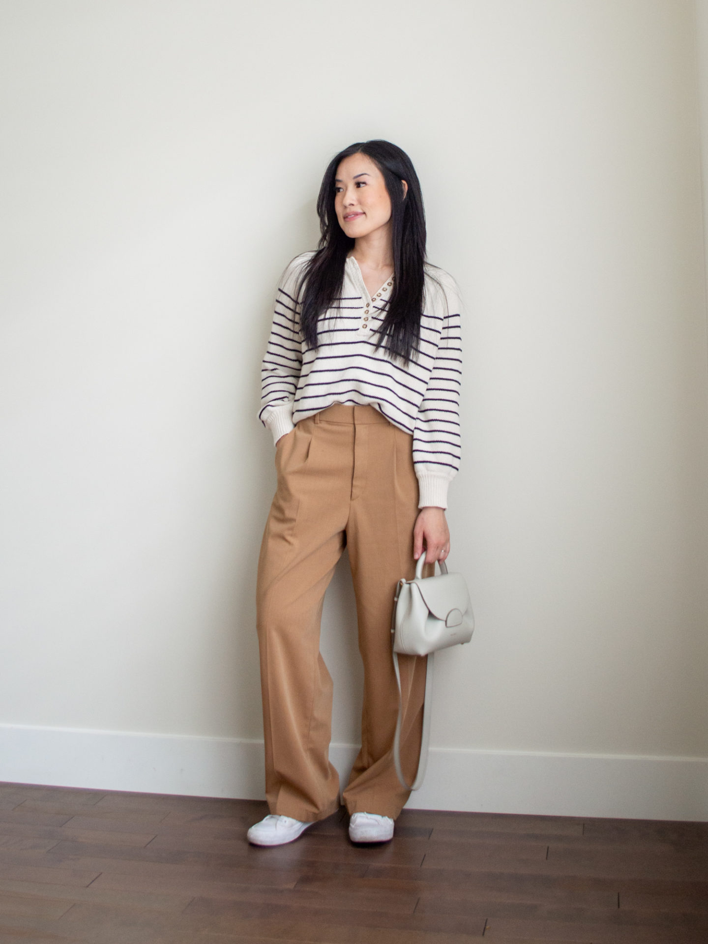 Sharon of Her Simple Sole is showcasing a outfit from her August outfit roundup featuring a striped cotton sweater, brown wide-leg pants, an off-white crossbody bag and a pair of white sneakers | minimalist outfits | simple outfit ideas