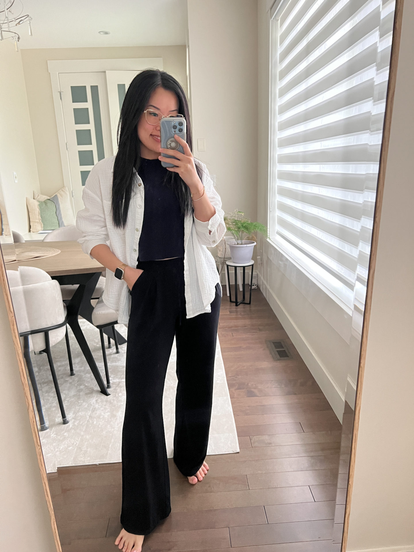 Sharon of Her Simple Sole is showcasing a outfit from her August outfit roundup, featuring a black ribbed cropped tank top, an oversized white button-up shirt, black wide-leg pants | minimalist outfits | simple outfit ideas