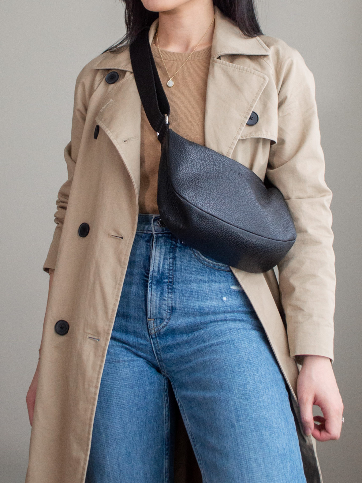 Close-up detailed outfit shot of Sharon of Her Simple Sole wearing a light brown cashmere sweater, brown trench coat, blue straight leg jeans and a black slouchy bag | minimalist outfits | fall outfit ideas | simple outfit ideas