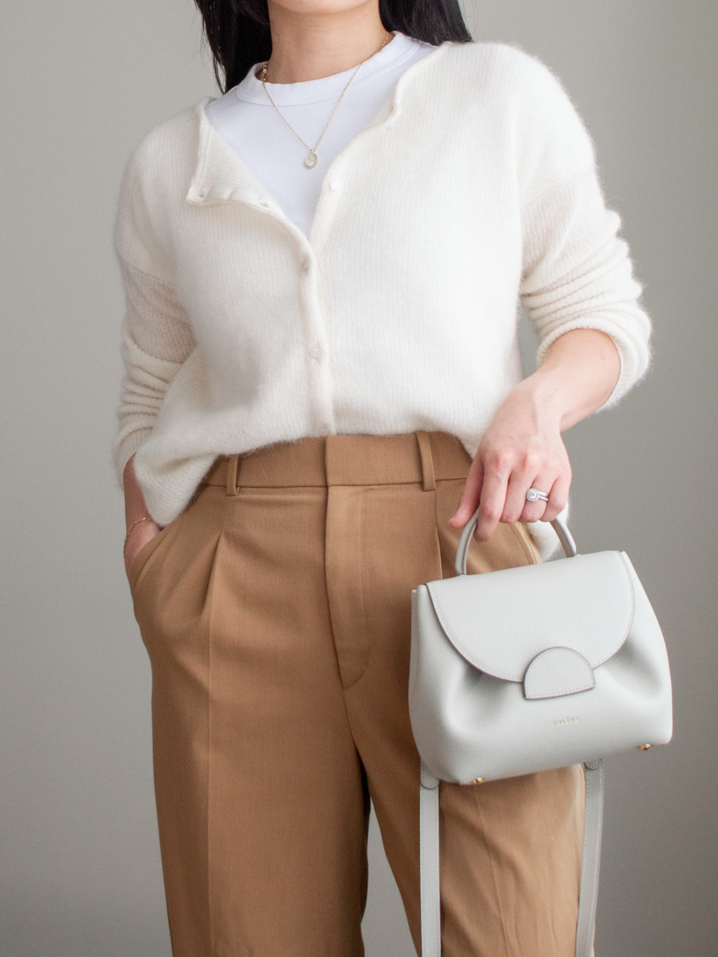 Close-up detailed outfit shot of Sharon of Her Simple Sole wearing a basic white T-Shirt, cream button-up cardigan, brown wide-leg pants, an off-white crossbody bag | minimalist outfits | fall outfit ideas | simple outfit ideas