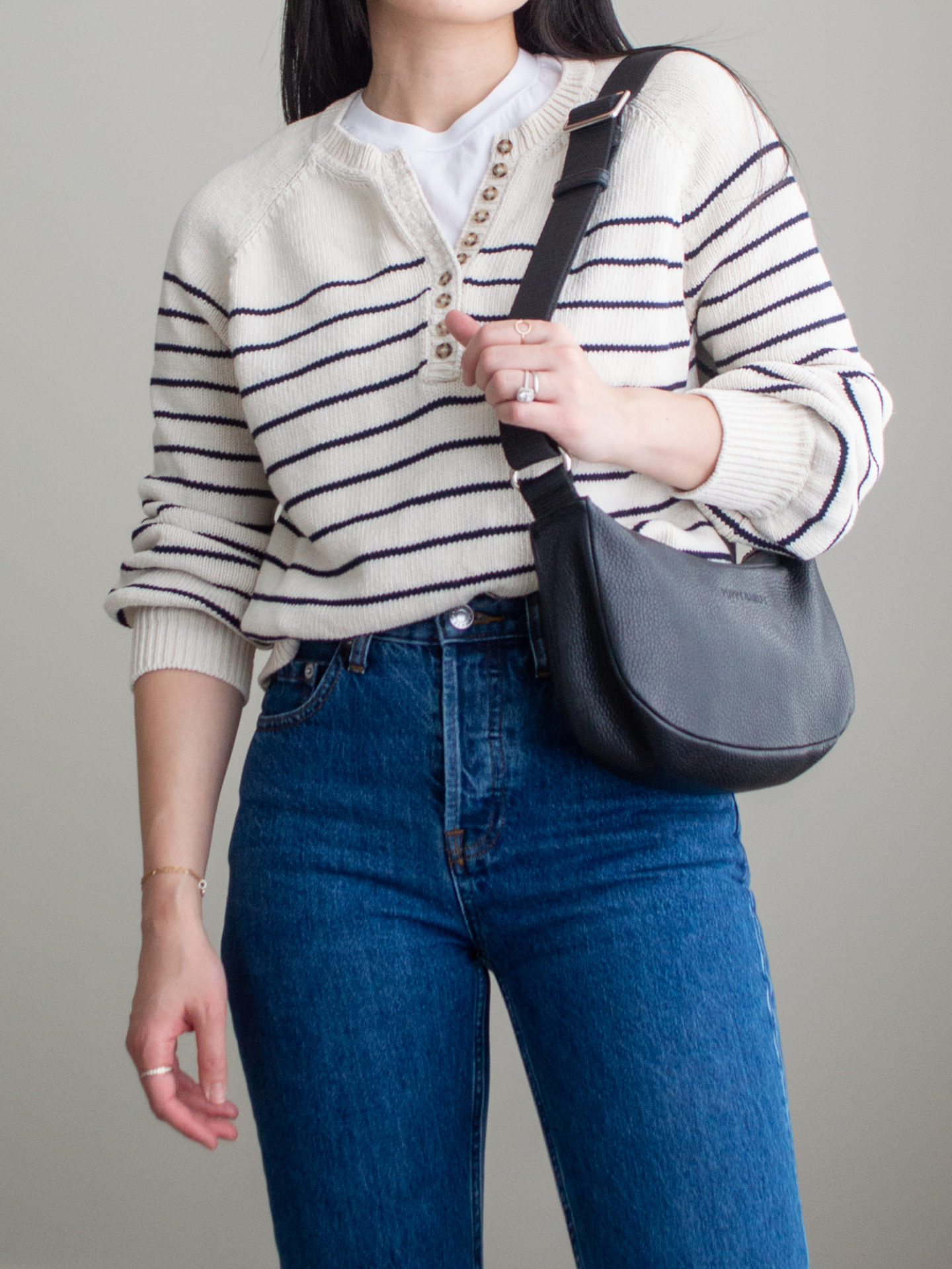 Close-up detailed outfit shot of Sharon of Her Simple Sole wearing a basic white T-Shirt, a striped cotton sweater, dark blue straight leg jeans and a black slouchy bag | minimalist outfits | simple outfit ideas