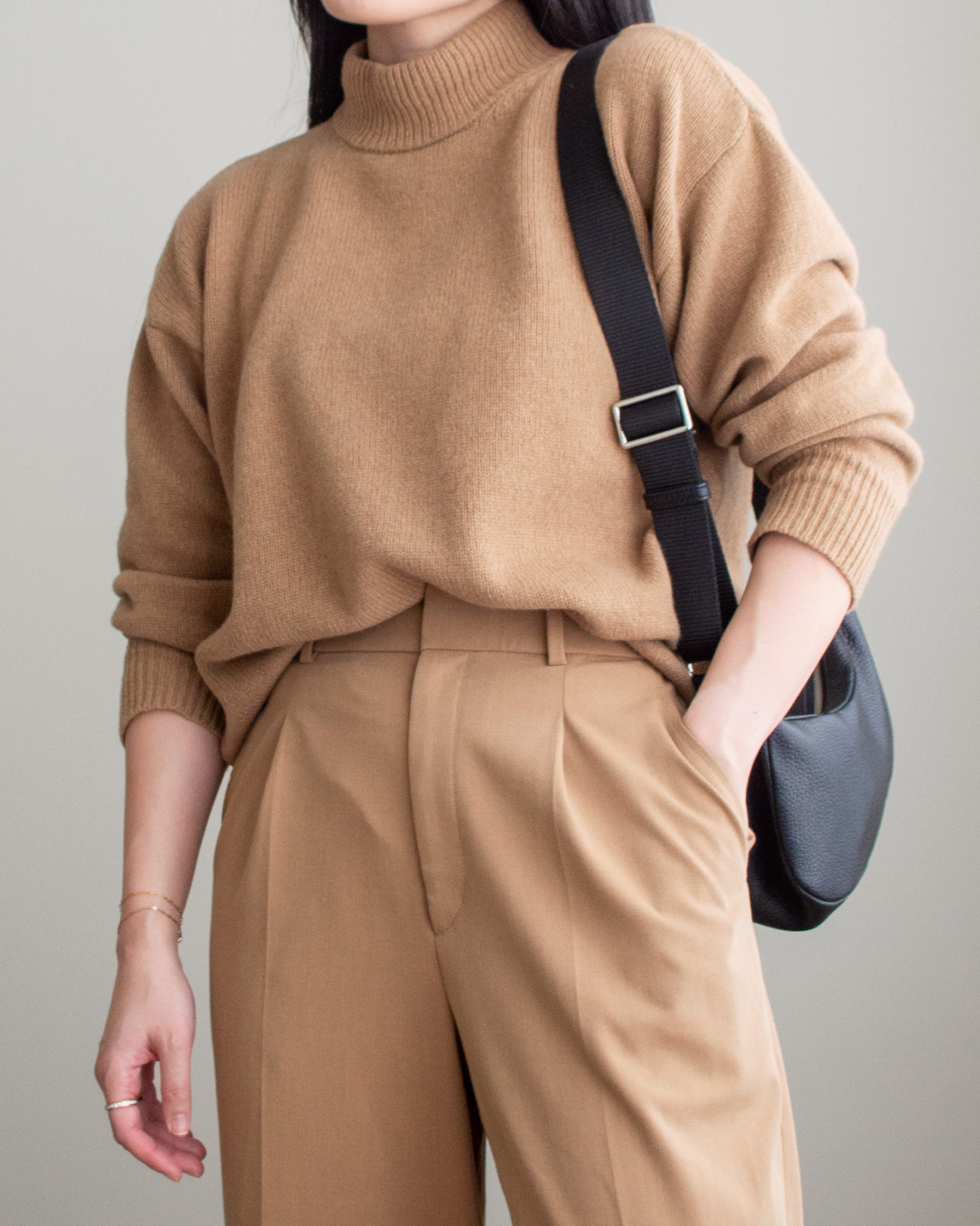 Close-up detailed outfit shot of Sharon of Her Simple Sole wearing a brown mockneck sweater, brown wide-leg pants and a black slouchy bag | minimalist outfits | simple outfit ideas