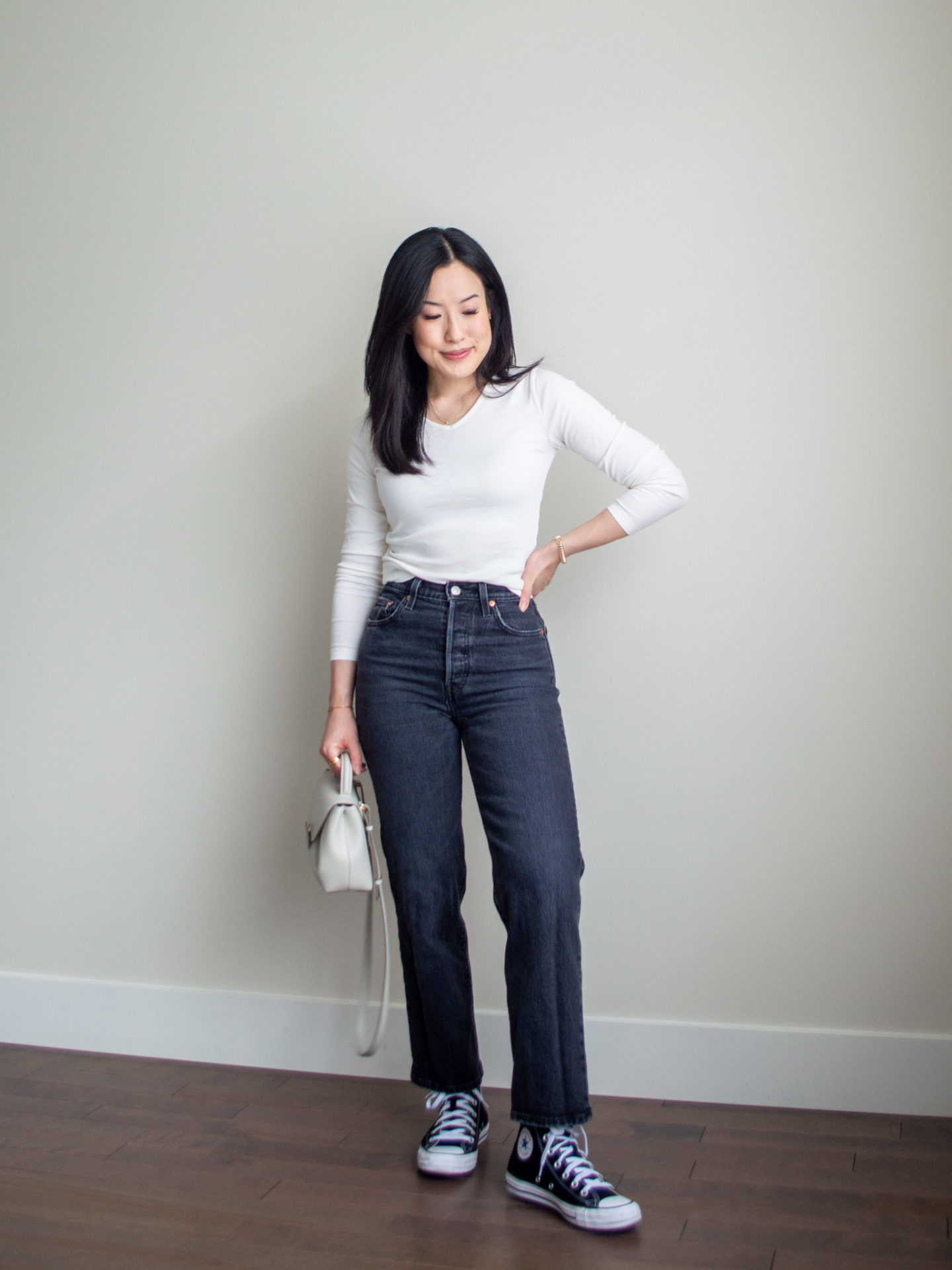 Sharon of Her Simple Sole is showcasing an outfit from weekend trip in a backpack featuring a white long sleeve shirt, grey straight leg jeans, black Converse sneakers and an off-white bag | minimalist outfits | fall outfit ideas | simple outfit ideas