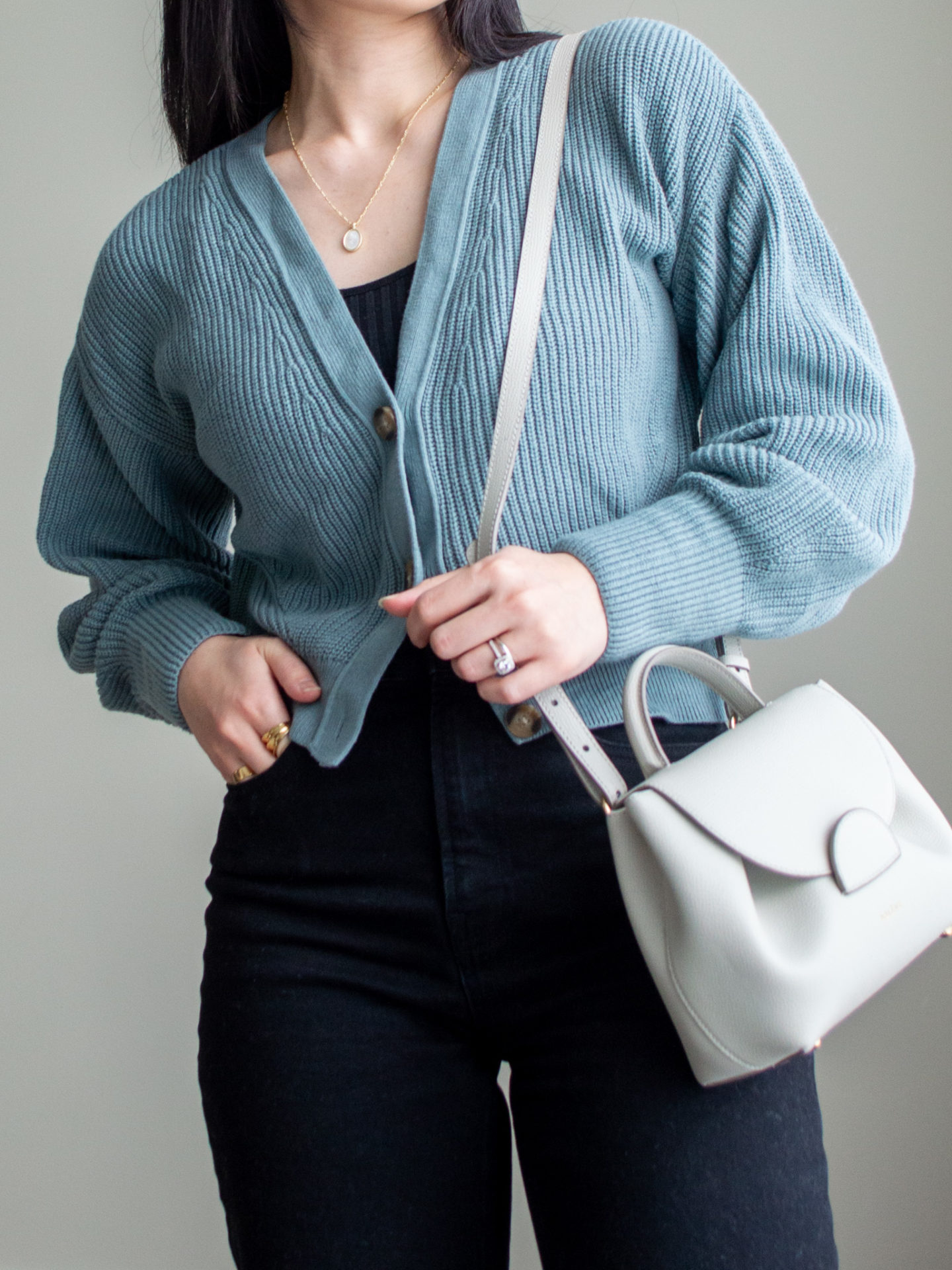 Close-up detailed outfit shot of Sharon of Her Simple Sole wearing a black ribbed tank top, a cropped cardigan, black straight leg jeans, and an off-white crossbody bag | minimalist outfits | simple outfit ideas