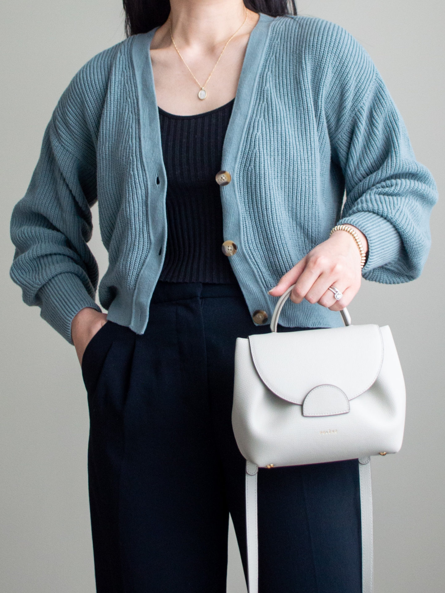 Close-up detailed outfit shot of Sharon of Her Simple Sole wearing a black ribbed tank top, a cropped cardigan, black wide leg pants, and an off-white crossbody bag | minimalist outfits | simple outfit ideas | cardigan and wide leg pants outfit